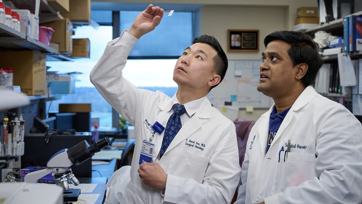 Dr. Seo and Dr. Chandrashekar in the laboratory examining a sample